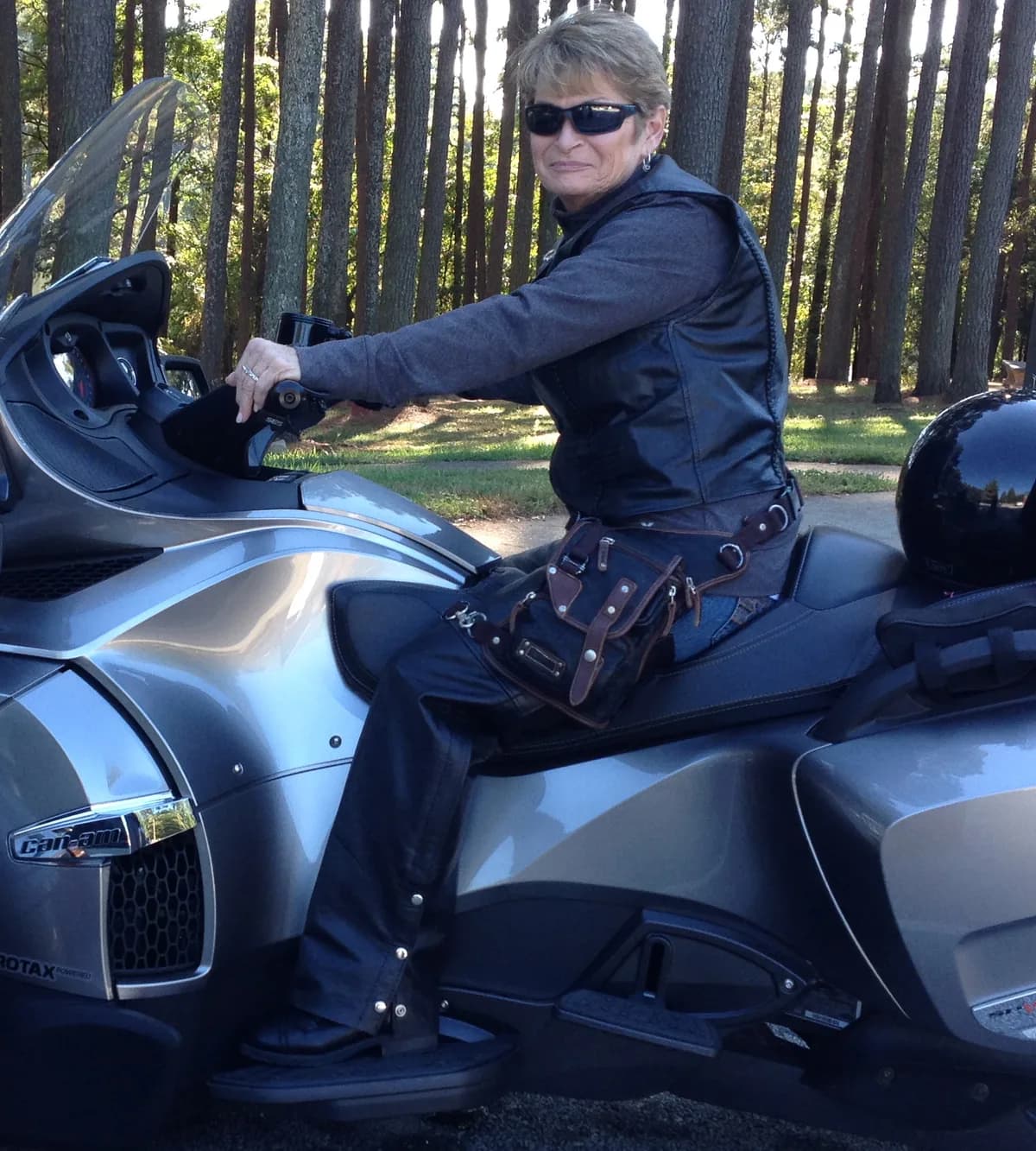Rider seated on a silver touring trike with a leather Ukoala bag worn on the thigh