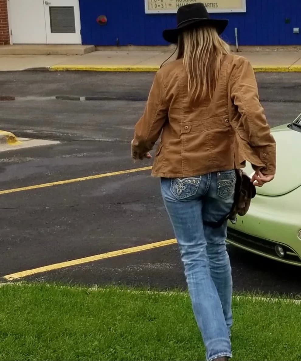 Customer in a western hat walking through a parking lot with a Ukoala bag at the hip